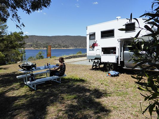 Ozcape Slide-On motorhome Woondabaa with lunch break setup overlooking a dam