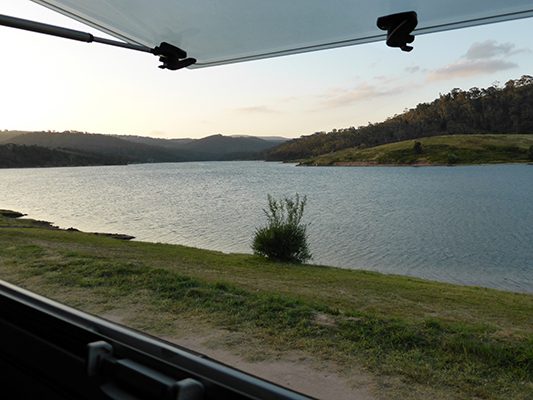 Ozcape Slide-On motorhome Woondabaa at rest stop overlooking a peaceful lake