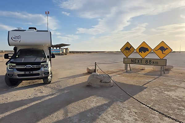Ozcape-Woondabaa-Slide On-truck camper Outback setting. Ozcape Woondabaa slide-on next to traffic signs warning of camels, wombats and kangaroos